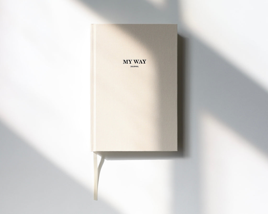 Beige linen My Way Journal on a minimal white background with soft natural sunlight, premium 12-month undated planner and reflection journal.
