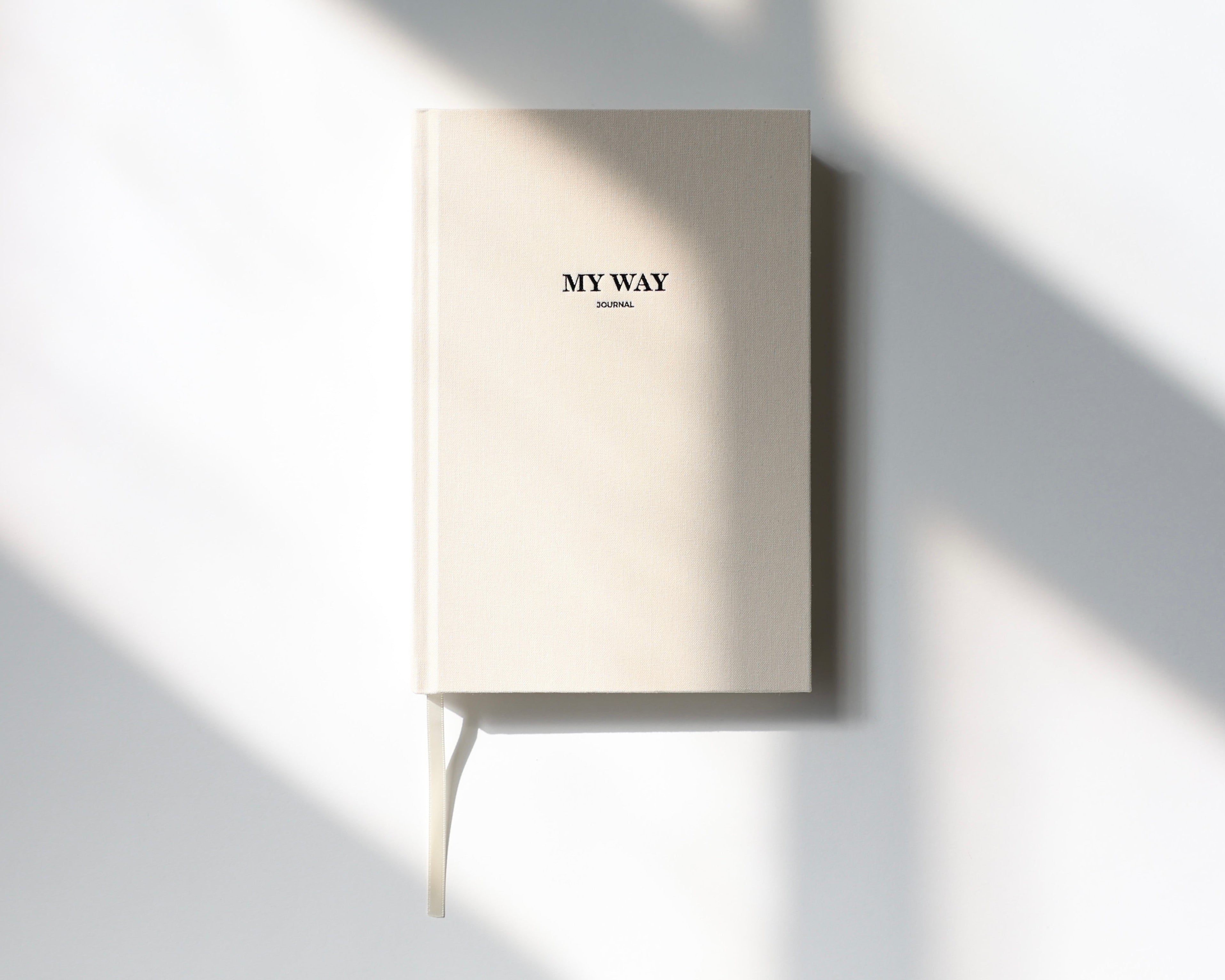 Beige linen My Way Journal on a minimal white background with soft natural sunlight, premium 12-month undated planner and reflection journal.